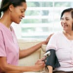 nurse checking a patients blood pressure while talking about weight loss medications and complications